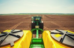 Tractor plowing farm field in preparation for spring planting.