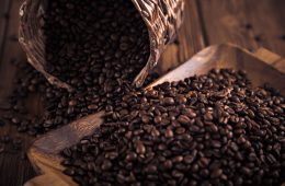 Roasted coffee beans close-up on a wooden surface.